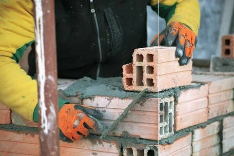 Industrial bricklayer installing bricks on construction site Industrial br... Stock Photos
