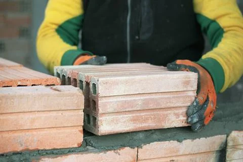 Industrial bricklayer installing bricks on construction site Industrial br... Stock Photos