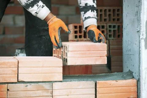 Industrial bricklayer installing bricks on construction site Industrial br... Stock Photos