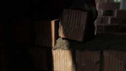 Industrial bricklayer worker placing bricks on cement while building exterior Stock Footage 127463804