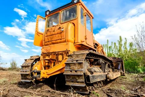 Industrial building construction site bulldozer leveling and moving soil duri Stock Photos