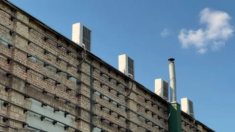 Industrial Building Rooftop with Multiple AC Units and Exhaust Pipe | Low-Angle Stock Footage 334956122