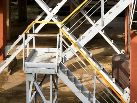 Industrial building structure fragment featuring metal staircases and pillars Foto stock
