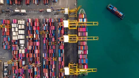 Industrial Cargo Ship Loading Containers At A Busy Seaport Terminal High An.. 库存照片