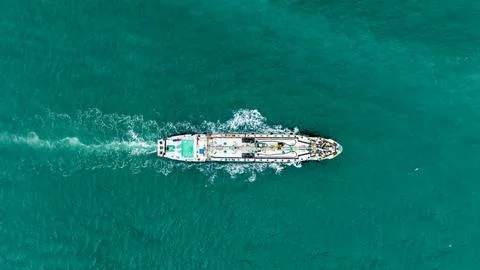 Industrial Cargo Ship Navigating Through Turquoise Tropical Waters High Ang.. Stock Photos