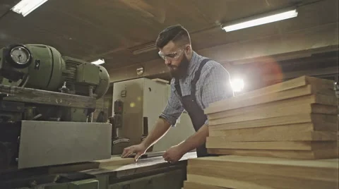 Industrial carpenter worker operating wood folding machine during wooden door Stock Footage