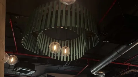 Industrial ceiling showcasing a concrete column, red conduit, spherical pendant Stock Footage 333512122