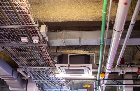Industrial ceiling utility installation with electrical wire trays, air con.. Foto stock
