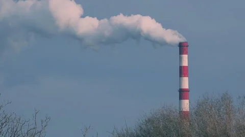 Industrial chimney emitting thick white smoke into blue sky, environmental Stock Footage 335380234
