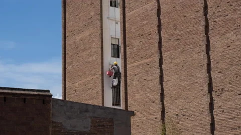 Industrial climber at work on the façade of an old building in Barcelona, Spain Stock Footage 194436574
