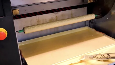 Industrial coating machine applying a yellow viscous liquid to a surface in a fa Stock Footage 331774878