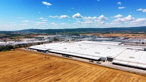 Industrial complex beyond golden harvested field Stock Footage 340556645