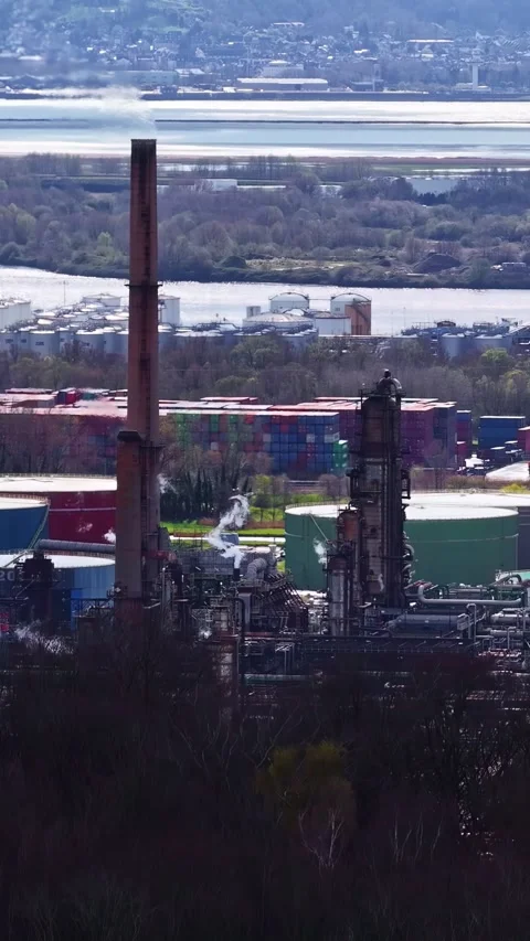 Industrial Complex with Chimneys and Shipping Containers by River Stock Footage 335364765