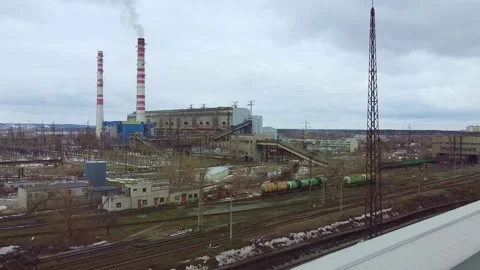 Industrial complex emitting smoke beside railway yard during daytime Stock-Footage 342625837