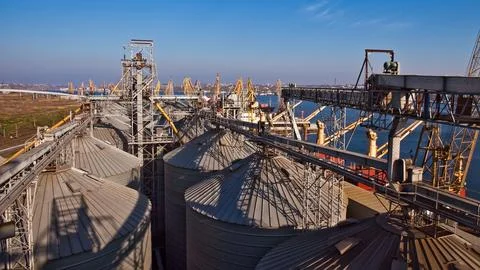 Industrial complex for grain processing with steel silos and conveyor systems. Stock Photos