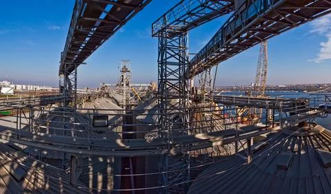 Industrial complex for grain processing with steel silos and conveyor systems. Stock Photos