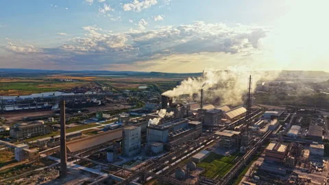 Industrial complex with pipes and smoke in the late afternoon sun near the Stock Footage 340962255