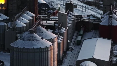 Industrial complex with storage silos and trains wagons on tracks during cold Stock Footage 333056601
