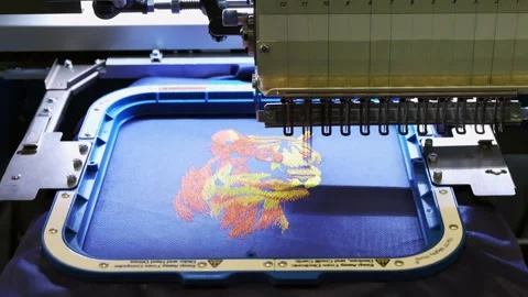 Industrial computerized embroidery machine sewing a colorful lion head desi.. Stock Footage 335137361