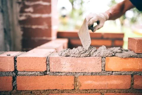 Industrial Construction bricklayer worker building walls with bricks, mortar  Stock Photos