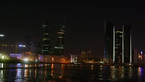 Industrial construction cranes illuminated at night along urban waterfront Stock Footage 337479729