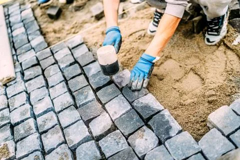 Industrial construction worker, handyman using cobblestone granite stones Stock Photos