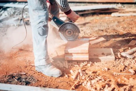 Industrial construction worker using a professional angle grinder Stock Photos