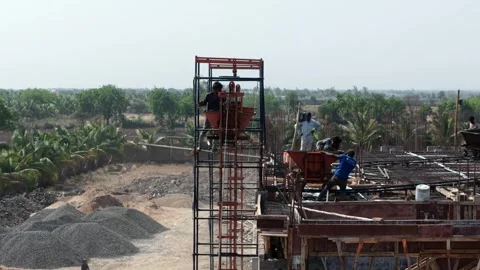 Industrial Construction Workers Operating Concrete Loading Equipment on Building Stock Footage 344230206