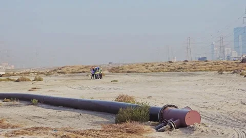 Industrial construction workers operating heavy machinery near a large pipeline Stock Footage 338308261