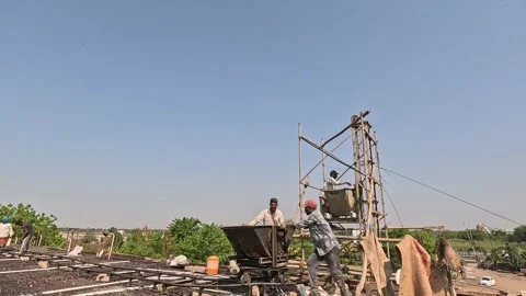 Industrial construction workers pouring concrete from a hopper at a height Stock Footage 343911738