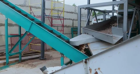 Industrial conveyor system transporting wood chips through metal processing 스톡 동영상 346317345