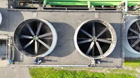 Industrial cooling system with large ventilation fans rotating above a concrete Stockbeeldmateriaal 341471625