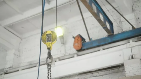 Industrial crane and hook in operation within a warehouse or workshop in factory Stock Footage 274490168