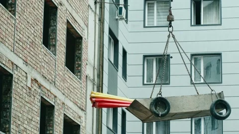 Industrial crane lifting construction materials to high floor Stock Footage 340628651