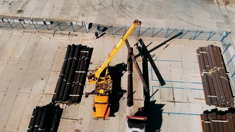 An industrial crane loads a section of Drilling pipes into a truck bed, Aerial 스톡 동영상 153147485