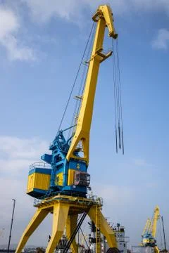 Industrial crane for unloading and loading in sea. Stock Photos