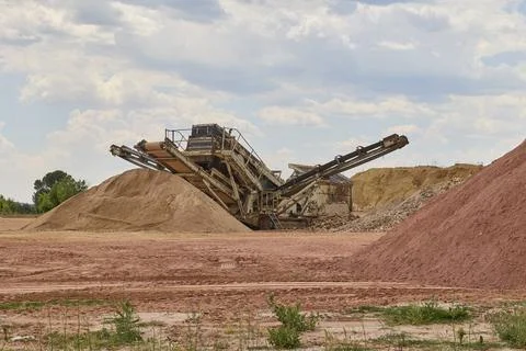 Industrial crushing machine processing aggregates in quarry site Stockfoto's