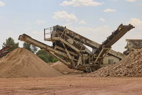 Industrial crushing machine processing aggregates in quarry site Stockfoto's