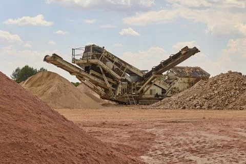 Industrial crushing machine processing aggregates in quarry site Stockfoto's