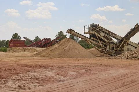 Industrial crushing machine processing aggregates in quarry site Stockfoto's