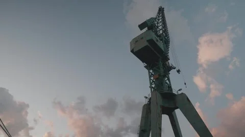 An Industrial Dock Featuring a Crane and a Vessel Alongside the Beautiful Sunset Stock Footage 302085384