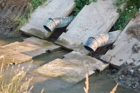 Industrial drainage system with heavy plastic sewage pipes discharging dirt.. Stock Photos