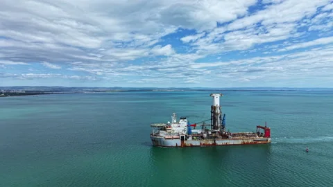 Industrial dredging vessel operates in open water near coastal area with clear Stock Footage 340144575