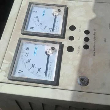 An industrial electrical control box featuring dual analog gauges for voltage Stock Photos