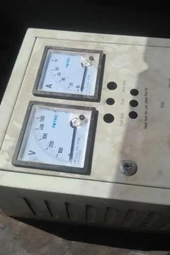 An industrial electrical control box featuring dual analog gauges for voltage Stock Photos