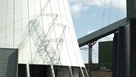Industrial Electrical Pylon Shadow Appears on Cooling Tower Stock Footage 74379697