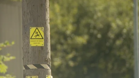 Industrial electricity post with warning signs neutral density version Stock Footage 112419997