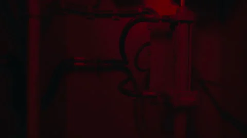 Industrial elevator machinery moving in a dark red lit shaft Stock Footage 335493509
