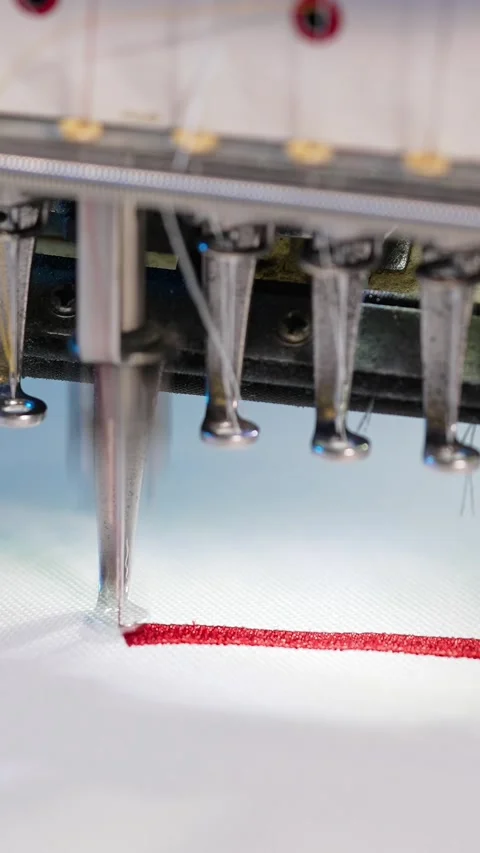 Industrial embroidery machine head stitching red thread on white fabric in .. Видео 337548183