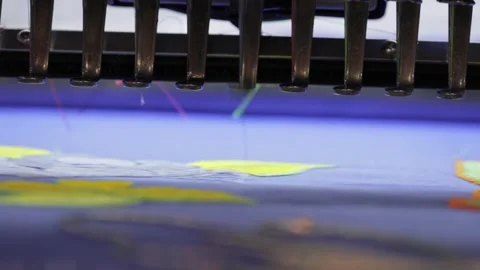 Industrial embroidery machine needle stitching yellow floral pattern on blu.. Stock Footage 337358598